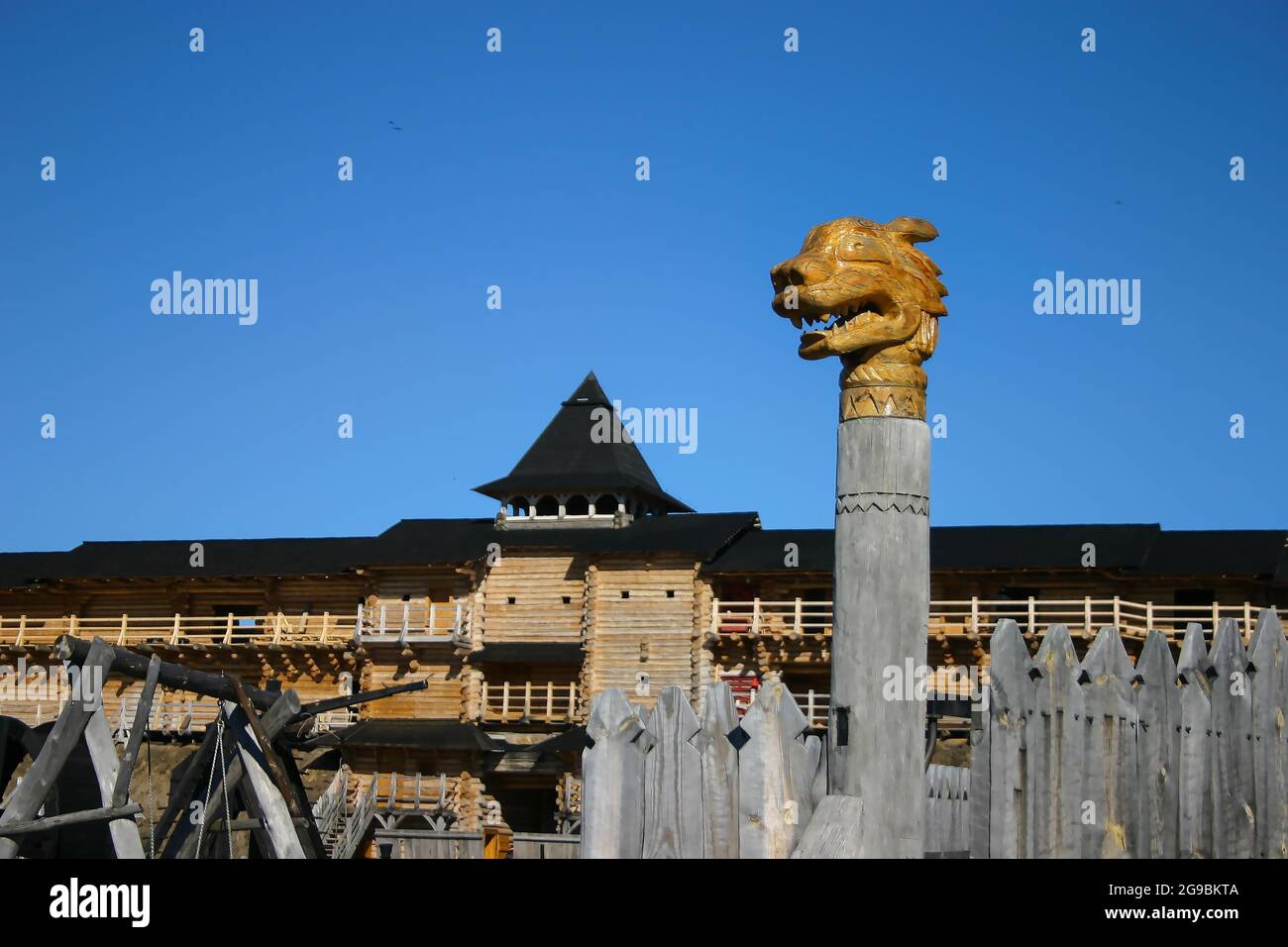 Der historische Park ist eine alte skandinavische Holzfestung mit einem Tor, das mit den Köpfen legendärer Drachen geschmückt ist. Totem handgemachte Holzsäulen. Rekon Stockfoto