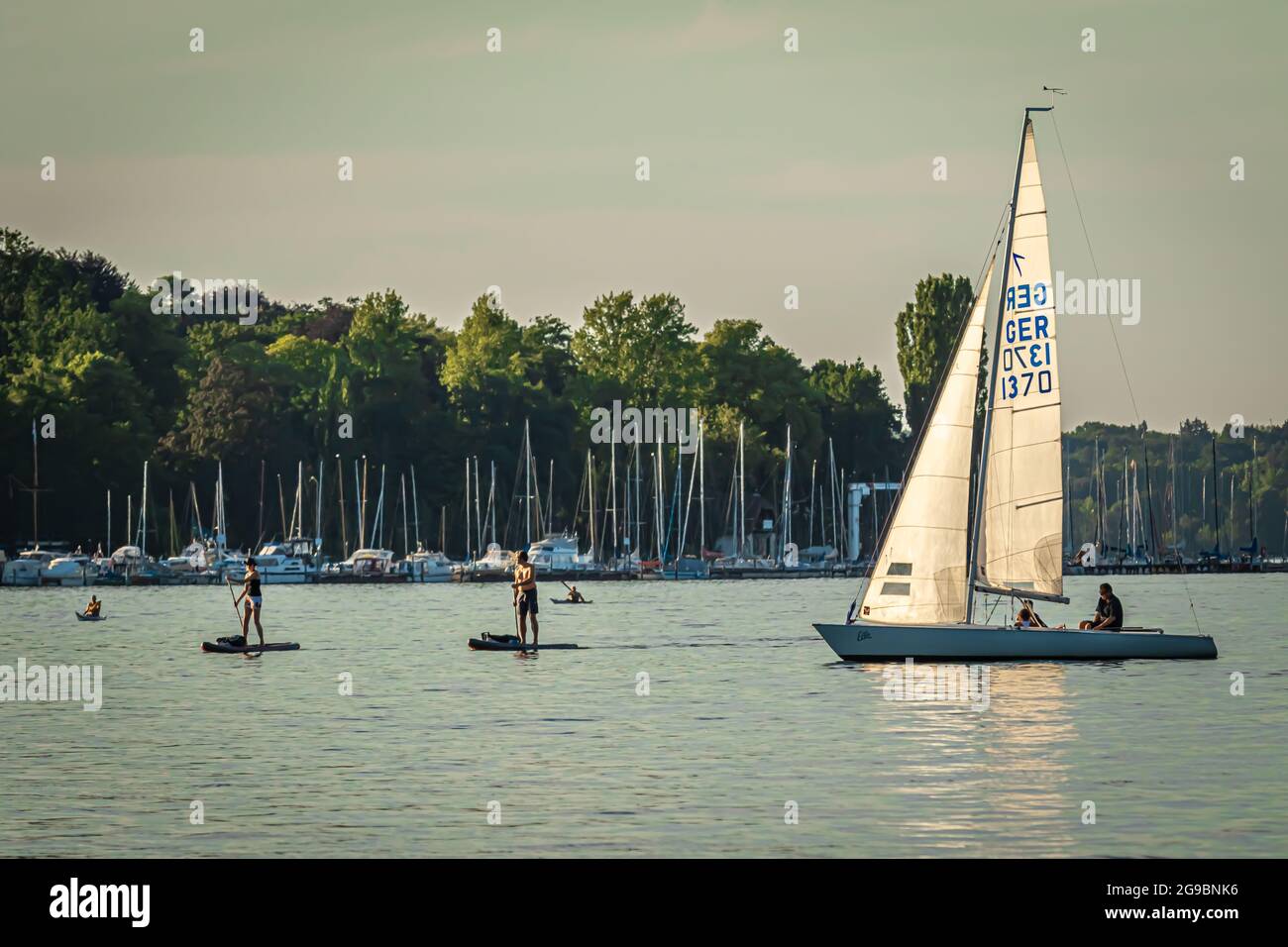 Berlin, Deutschland - 24. Juli 2019: Wassersportler am Wannsee mit Segelbooten, Paddelbrettern, Kajaks Stockfoto