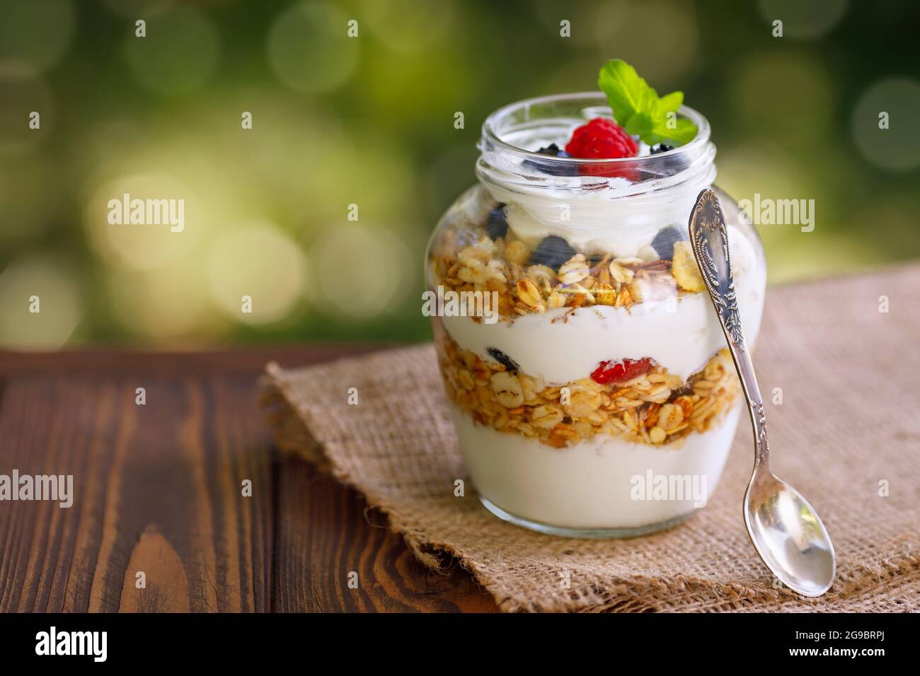Müsli mit griechischem Joghurt und Beeren im Glasgefäß Stockfoto