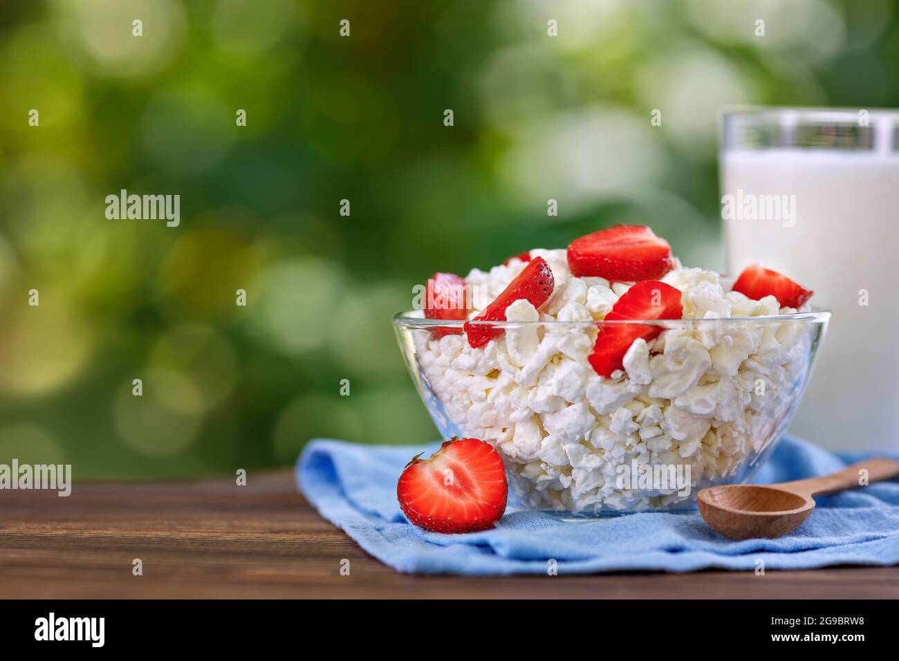 Joghurt und Quark mit frischer Erdbeere auf dem Tisch im Freien Stockfoto