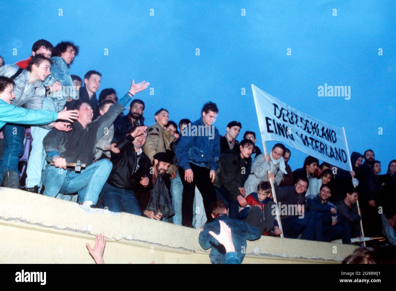 Nach der offiziellen Eröffnung des Brandenburger Tors - 1989 feiert eine Menschenmenge auf der Berliner Mauer Stockfoto