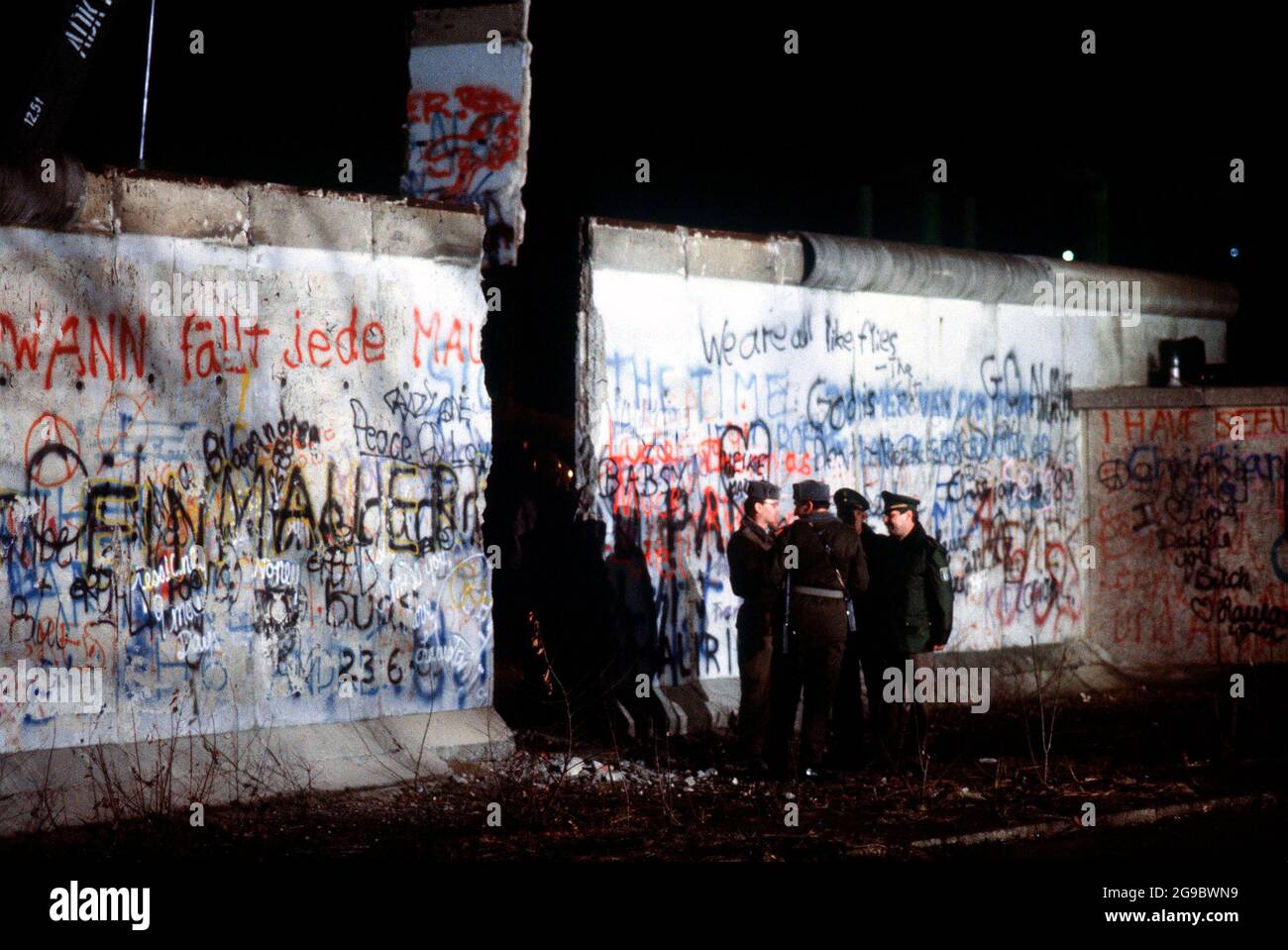 Ost- und Westdeutsche Wachen unterhalten sich über die neu geschaffene Öffnung in der Berliner Mauer, nachdem ein Kran einen Teil des Bauwerks neben dem Brandenburger Tor 1989 entfernt hatte Stockfoto