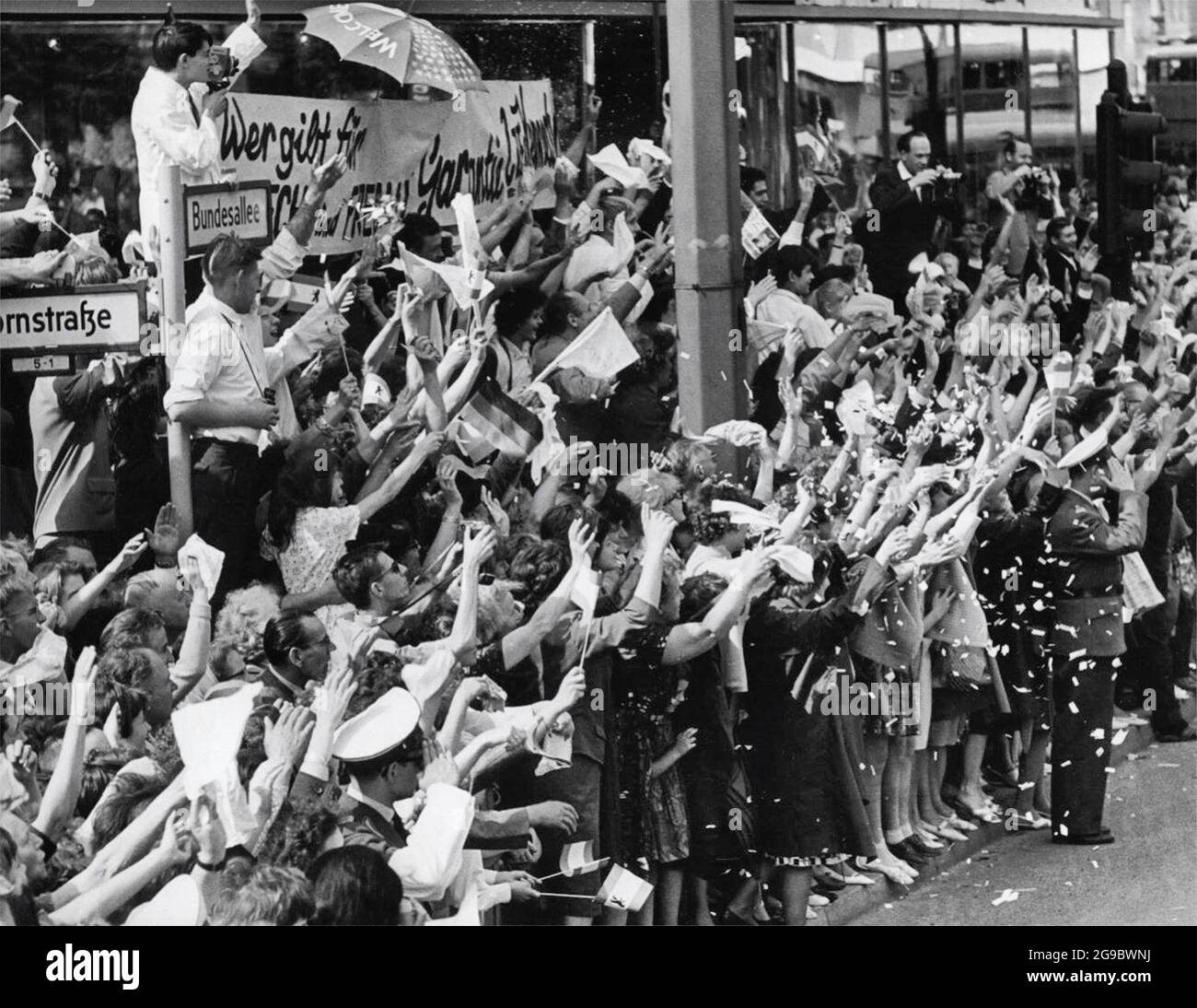 Berlin Street Crowd Waves Gruß Als Präsident Kennedy Vorbeikommt - 26. Juni 1963 Stockfoto