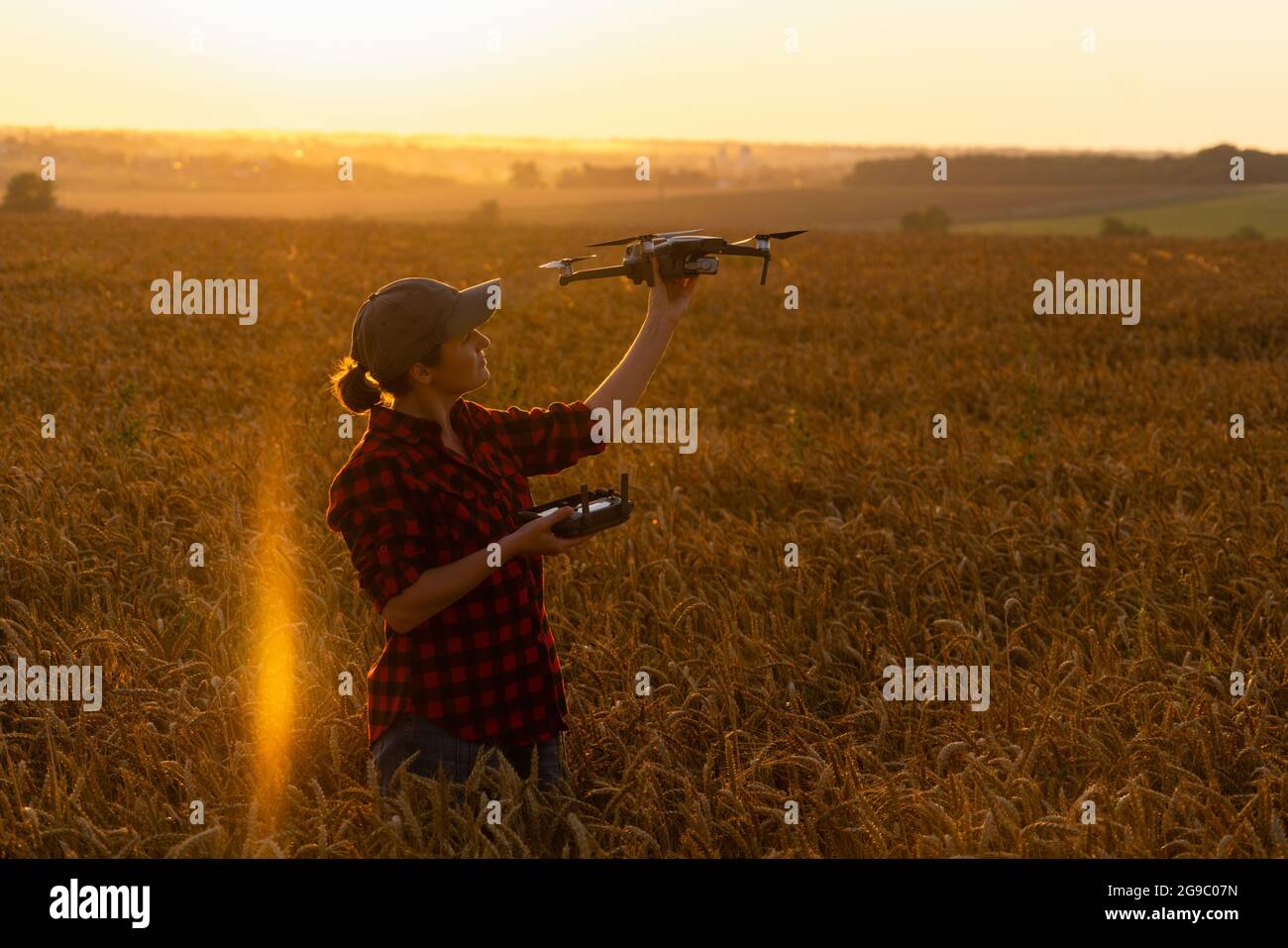 Bäuerin mit Drohne auf einem Weizenfeld. Intelligente Landwirtschaft und Präzisionslandwirtschaft Stockfoto