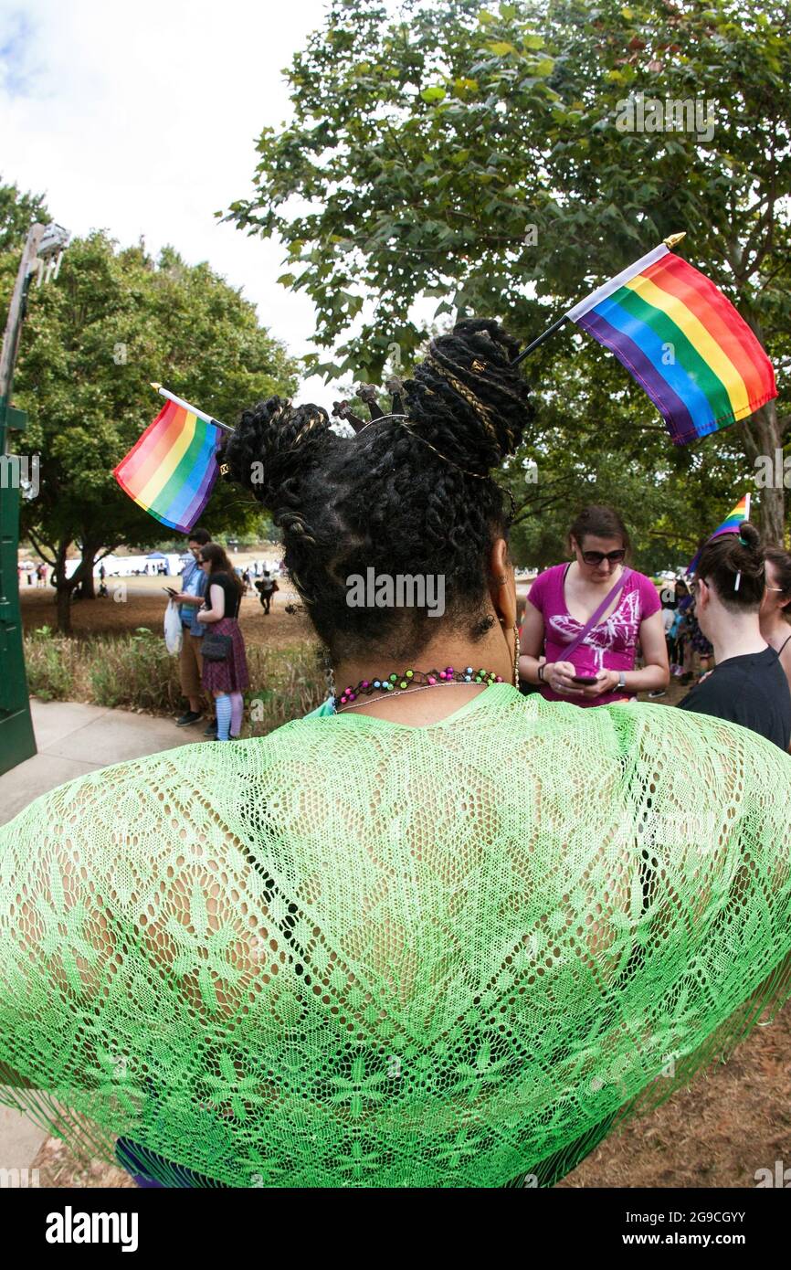Atlanta, GA, USA - 12. Oktober 2019: Eine Frau trägt zwei kleine Gay Pride Flaggen im Haar, bevor sie an der Atlanta Transgender Parade teilnimmt. Stockfoto