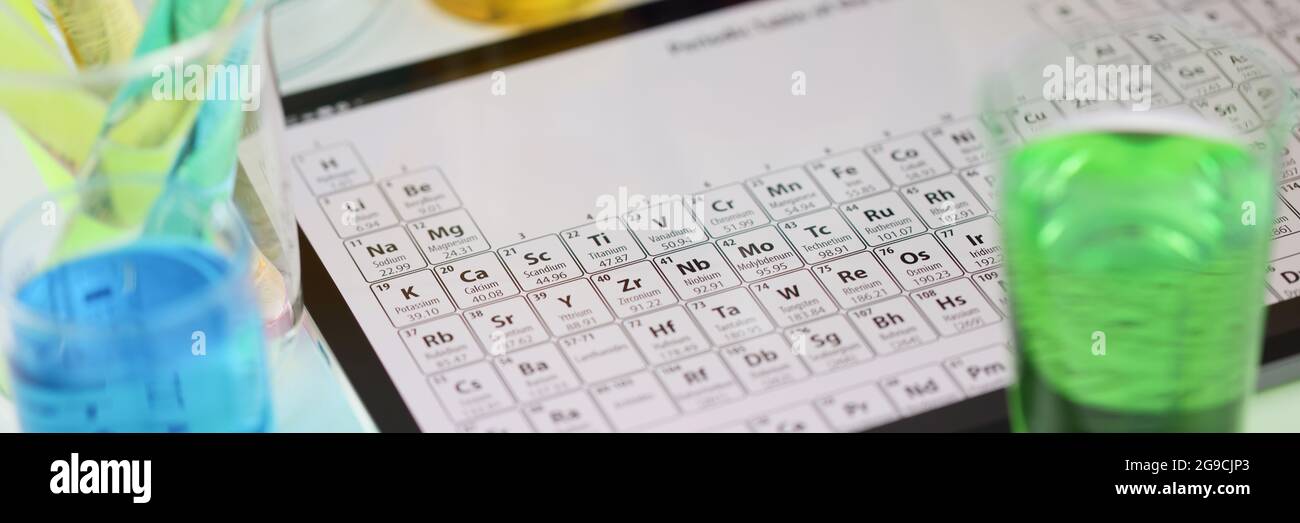 Digitales Tablet mit periodischem System von Elementen, die auf dem Tisch liegen In der Nahaufnahme des Labors Stockfoto