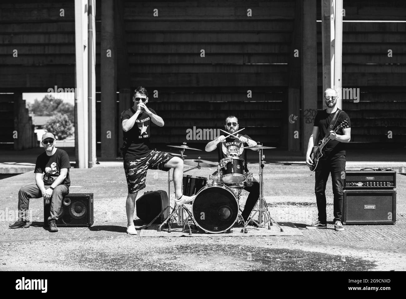 BRCKO, BOSNIEN UND HERZEGOWINA - 26. Jun 2020: Eine monochrome Aufnahme einer Rockband, die an einem heißen Sommertag im Freien auftrat. Stockfoto