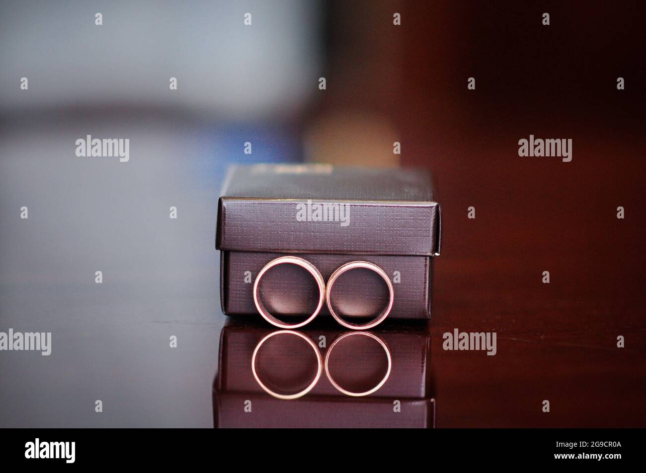 Zwei Eheringe in der Nähe der Geschenkbox. Stockfoto