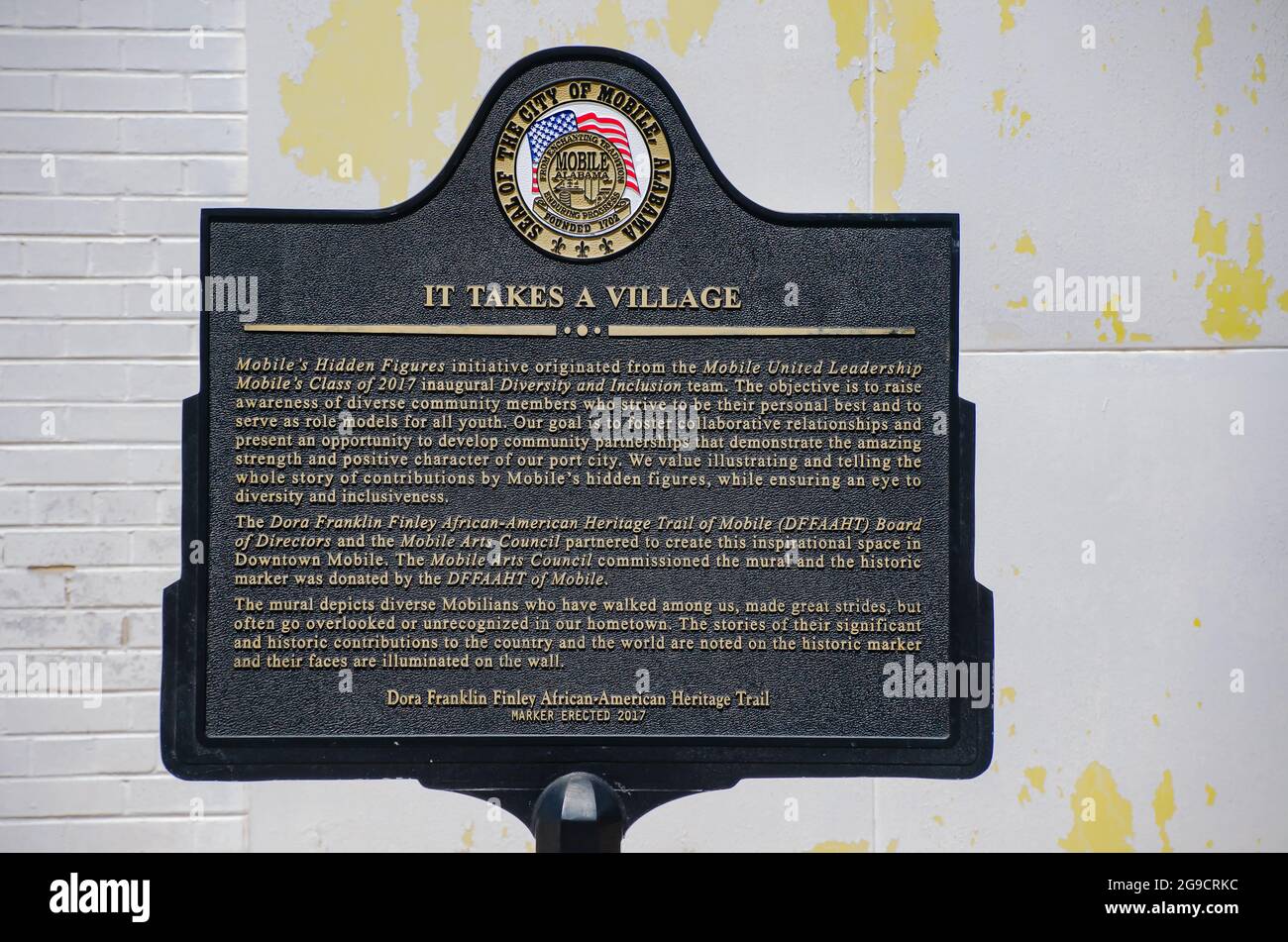 Eine historische Markierung steht neben dem „IT Takes a Village Mural“, der bemerkenswerte Mobilianer zeigt, 23. Juli 2021, in Mobile, Alabama. Stockfoto