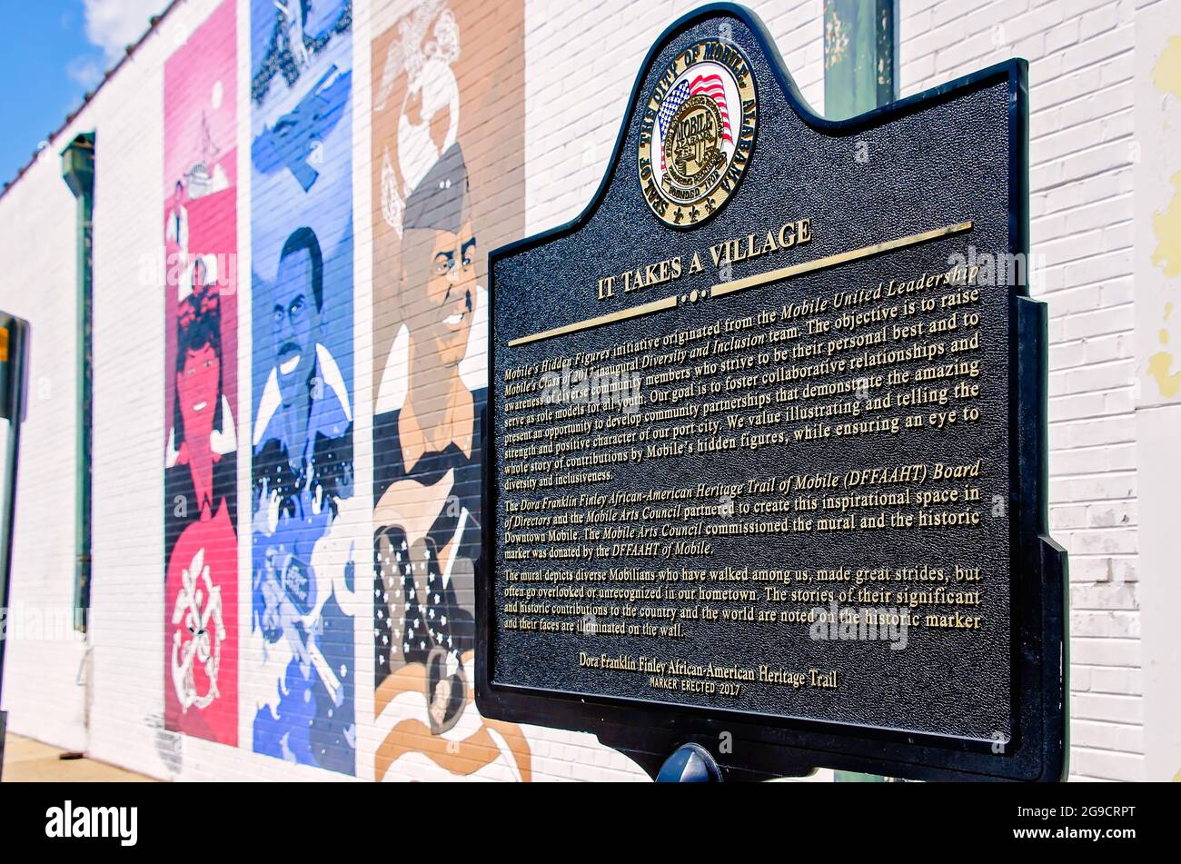 Eine historische Markierung steht neben dem „IT Takes a Village Mural“, der bemerkenswerte Mobilianer zeigt, 23. Juli 2021, in Mobile, Alabama. Stockfoto