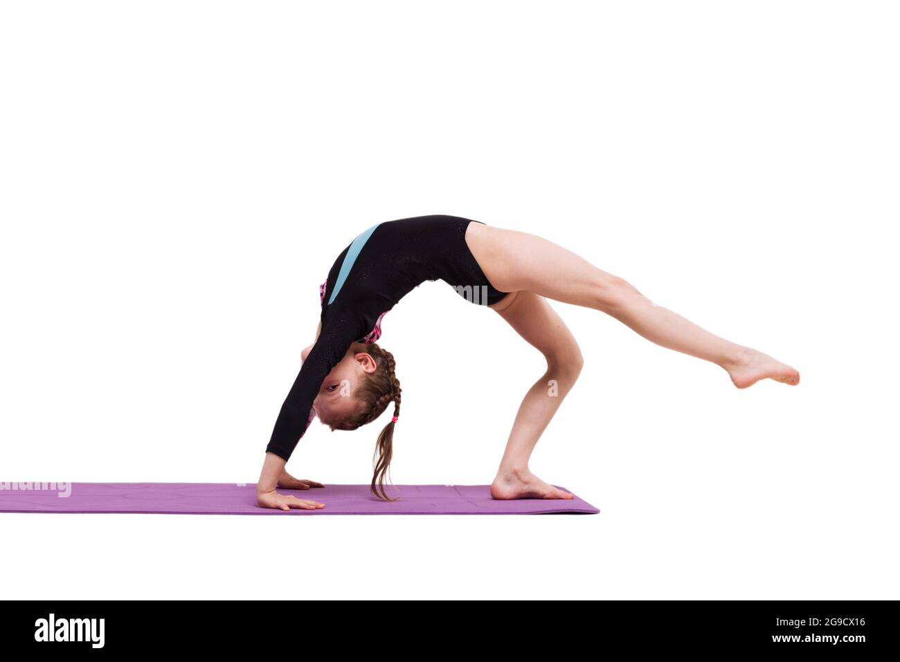 Nettes Kind Mädchen macht Gymnastik Übungen gegen weiß. Stockfoto