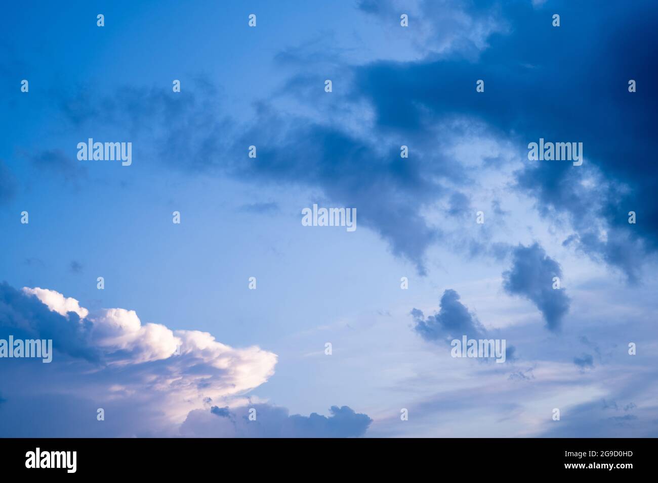 Dramatische Wolken am strahlend blauen Himmel mit strahlend weißer Vorderkante Stockfoto