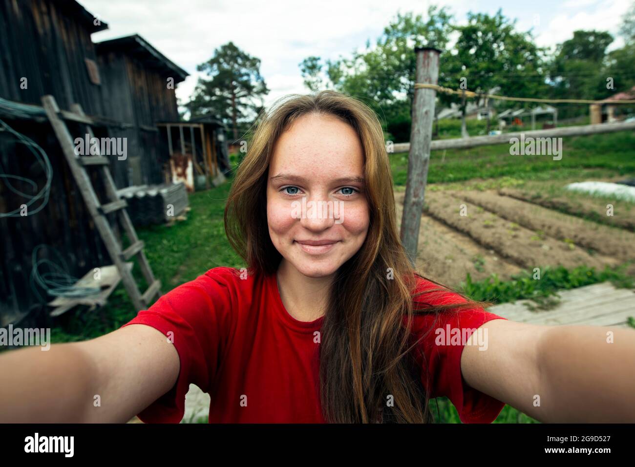 Ein Teenager-Mädchen macht ein Selfie im Dorf. Stockfoto