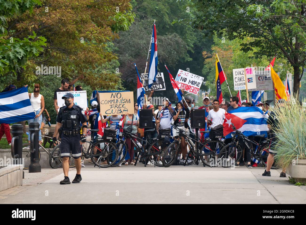 Kubanisch-kanadische Bürger, die ein freies Kuba forderten, stehen hinter einer Polizeiblockade, während sie gegen ein Pro-Kommunismus-Ereignis in Toronto, Kanada, protestierten. Stockfoto