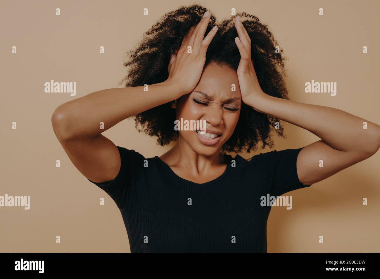Schockierte afroamerikanische gestresste Mädchen hält die Hände auf den Kopf und zeigt Verzweiflung Stockfoto