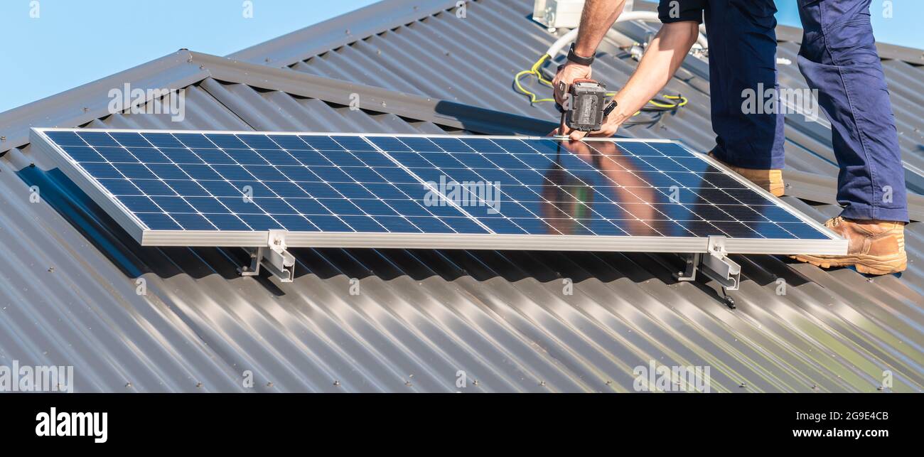 Nicht identifizierter Mann, der das Solarpanel am Dachträger befestigt Stockfoto