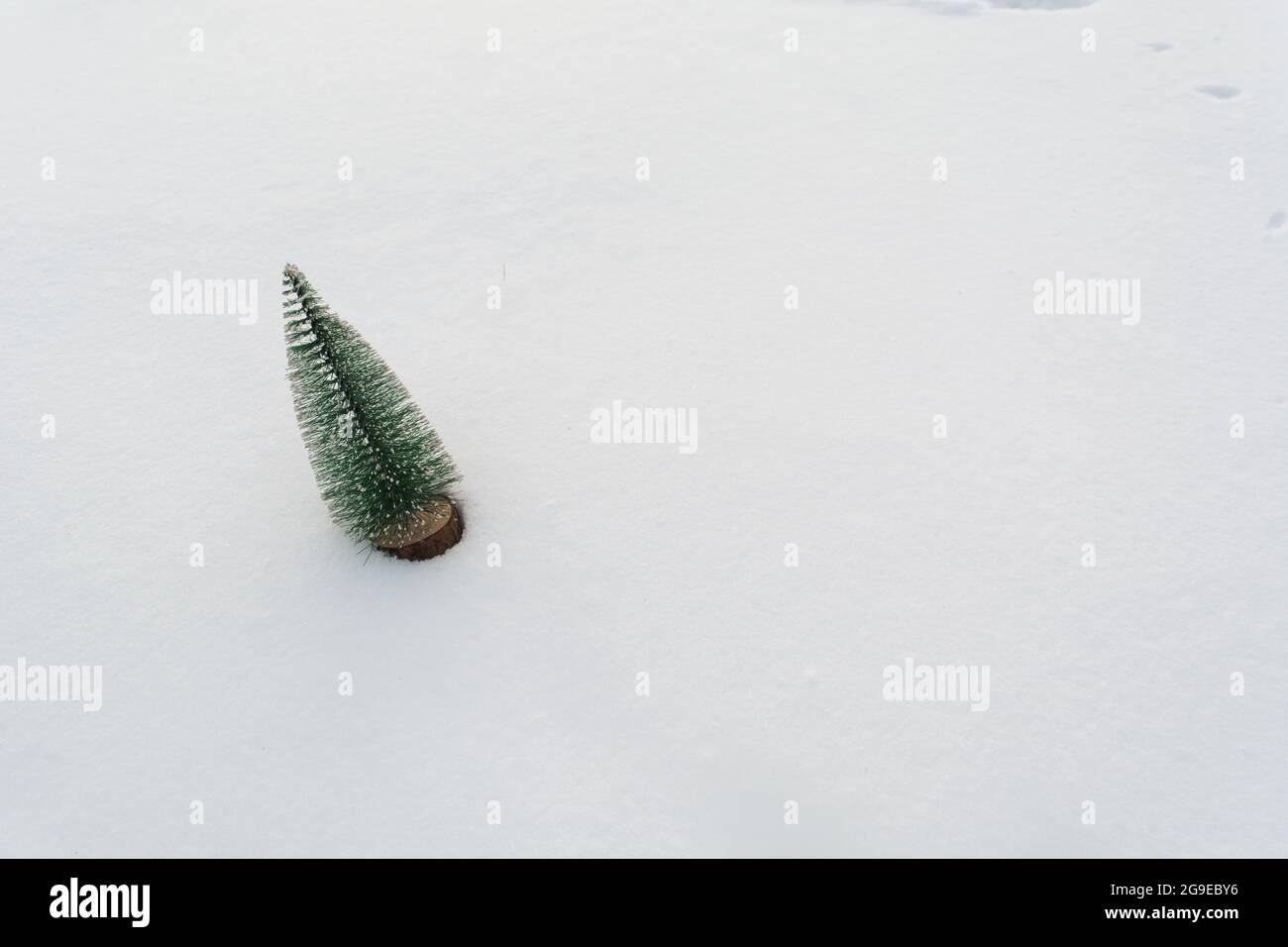 Weihnachtsbaum aus Plastik auf echtem Schnee mit Kopierplatz. Winter Urlaub Hintergrund Stockfoto