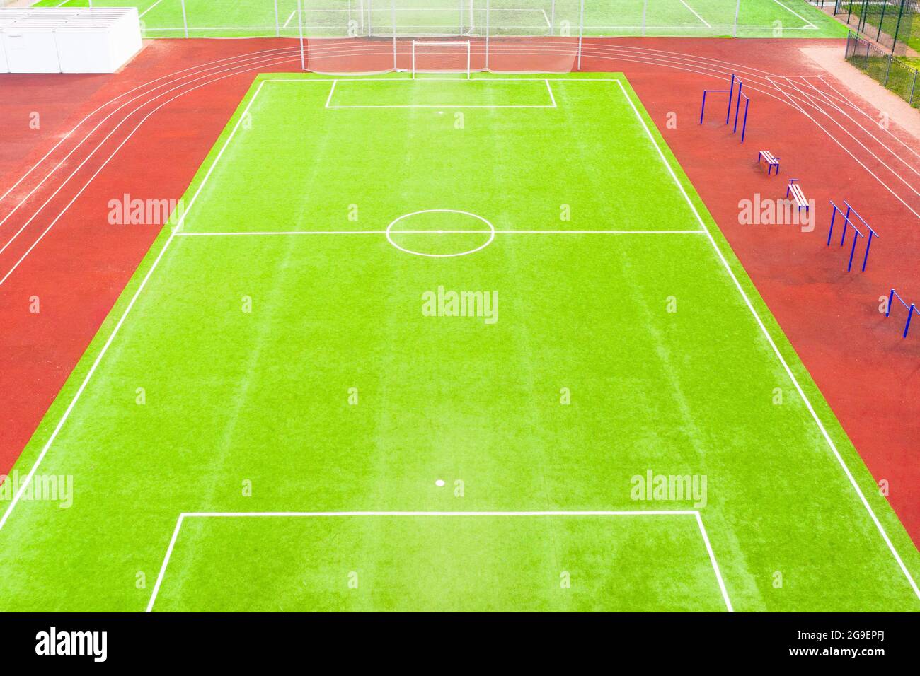 Fußballplatz mit Kunstrasen und roten Laufstrecken, Luftaufnahme Stockfoto