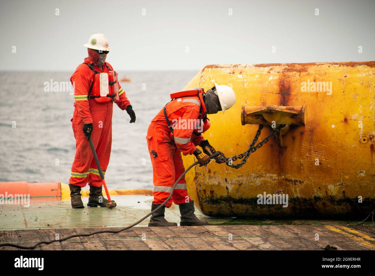 Die Schiffsbesatzung, die während der Ankerabfertigung auf See an Deck arbeitet Stockfoto