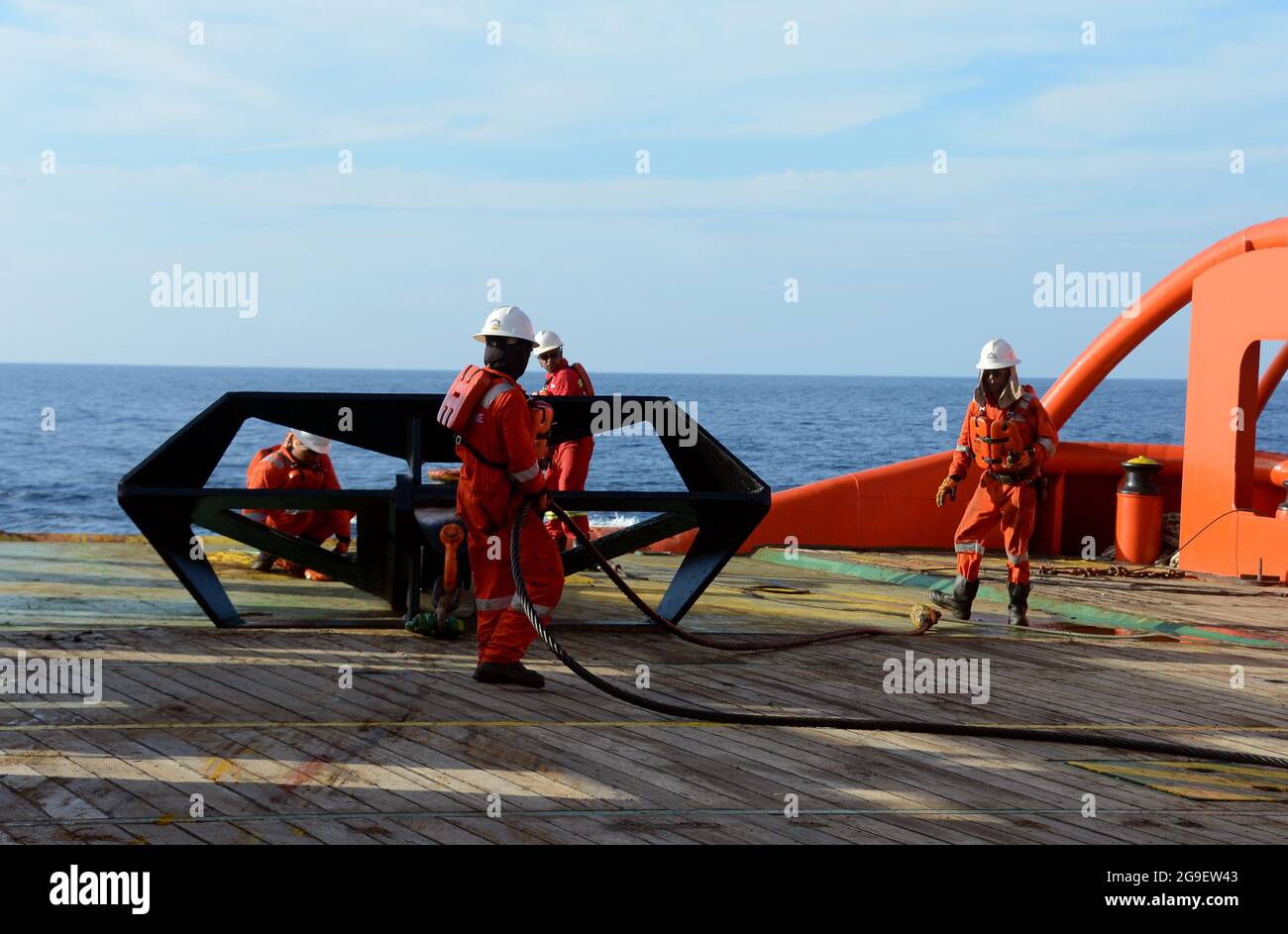 Die Schiffsbesatzung, die während des Frachtumschlags an Deck für die Aufbockvorrichtung auf See arbeitet Stockfoto