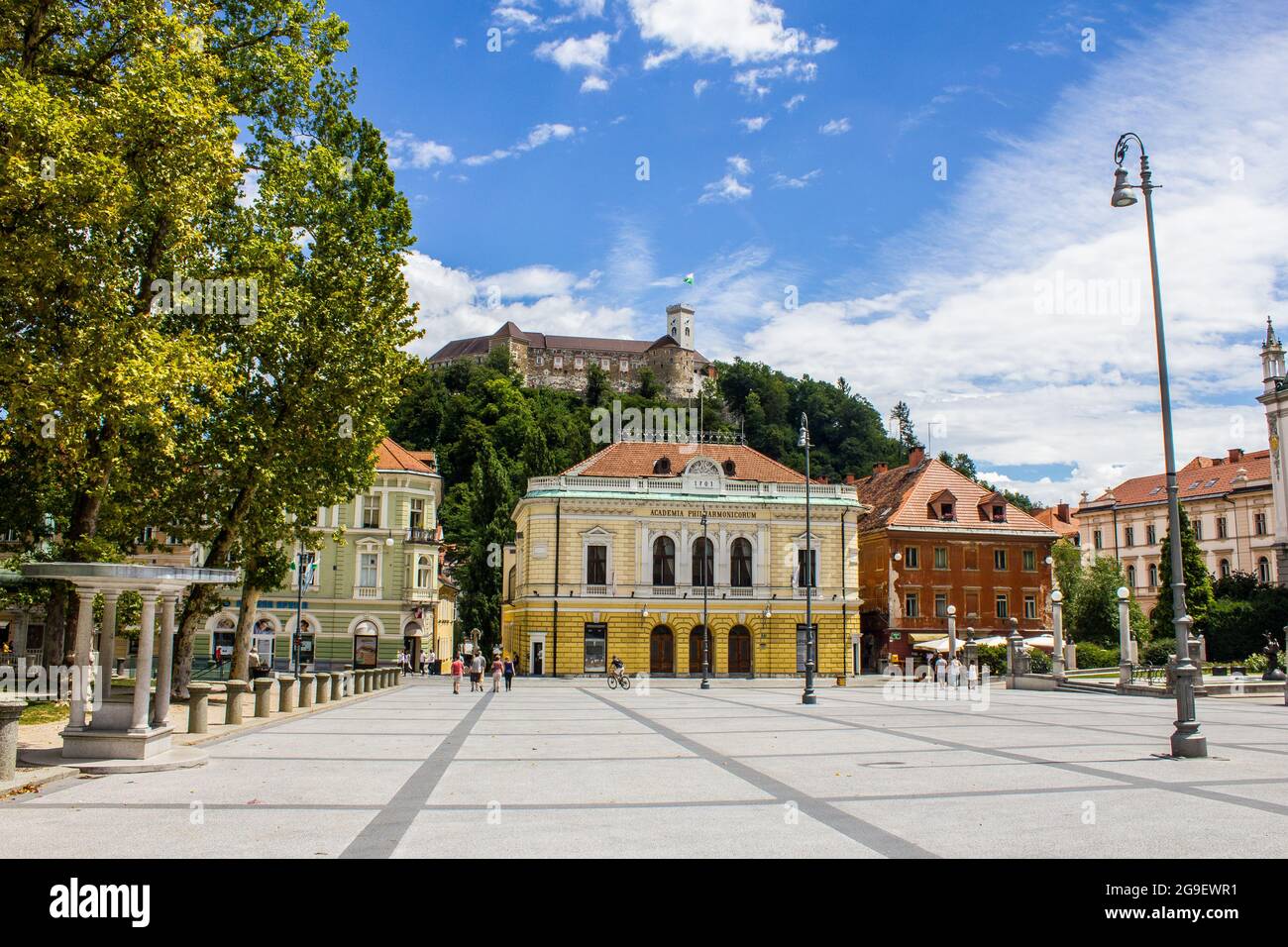 Ljubljana, Slowenien - 15. Juli 2017: Philharmonisches Gebäude auf dem Kongressplatz mit der Burg von Ljubljana im Hintergrund Stockfoto