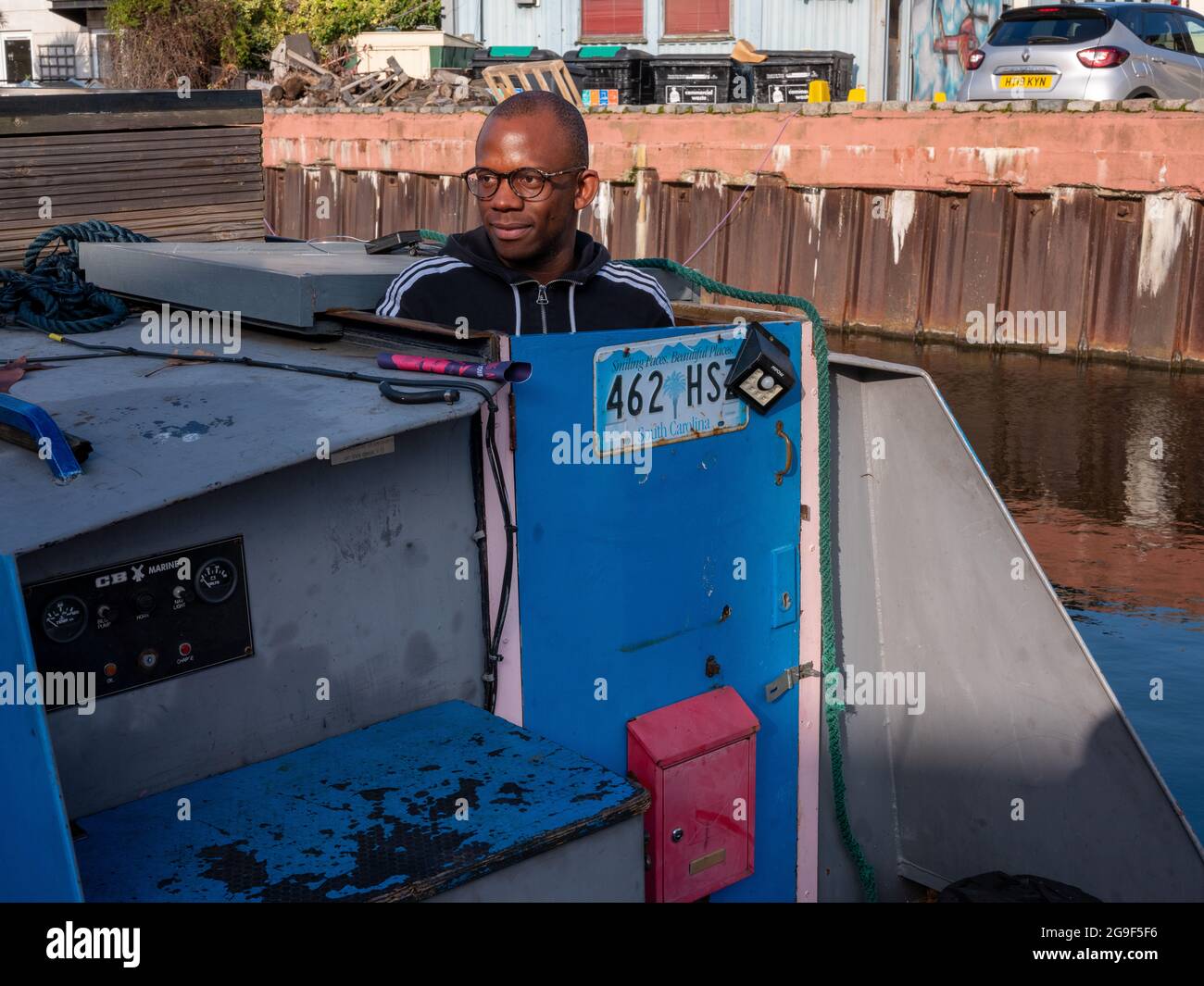 Ein schwarzer Mann auf einem schmalen Boot entlang des Regent’s Canal in Little Venice, London Stockfoto