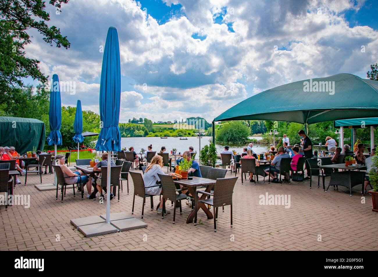 SPENGE, DEUTSCHLAND. 20. JUNI 2021. Hoocker Moor Ranch. Blick auf den See, Menschen, die sich auf dem Café am Ufer ausruhen. Stockfoto