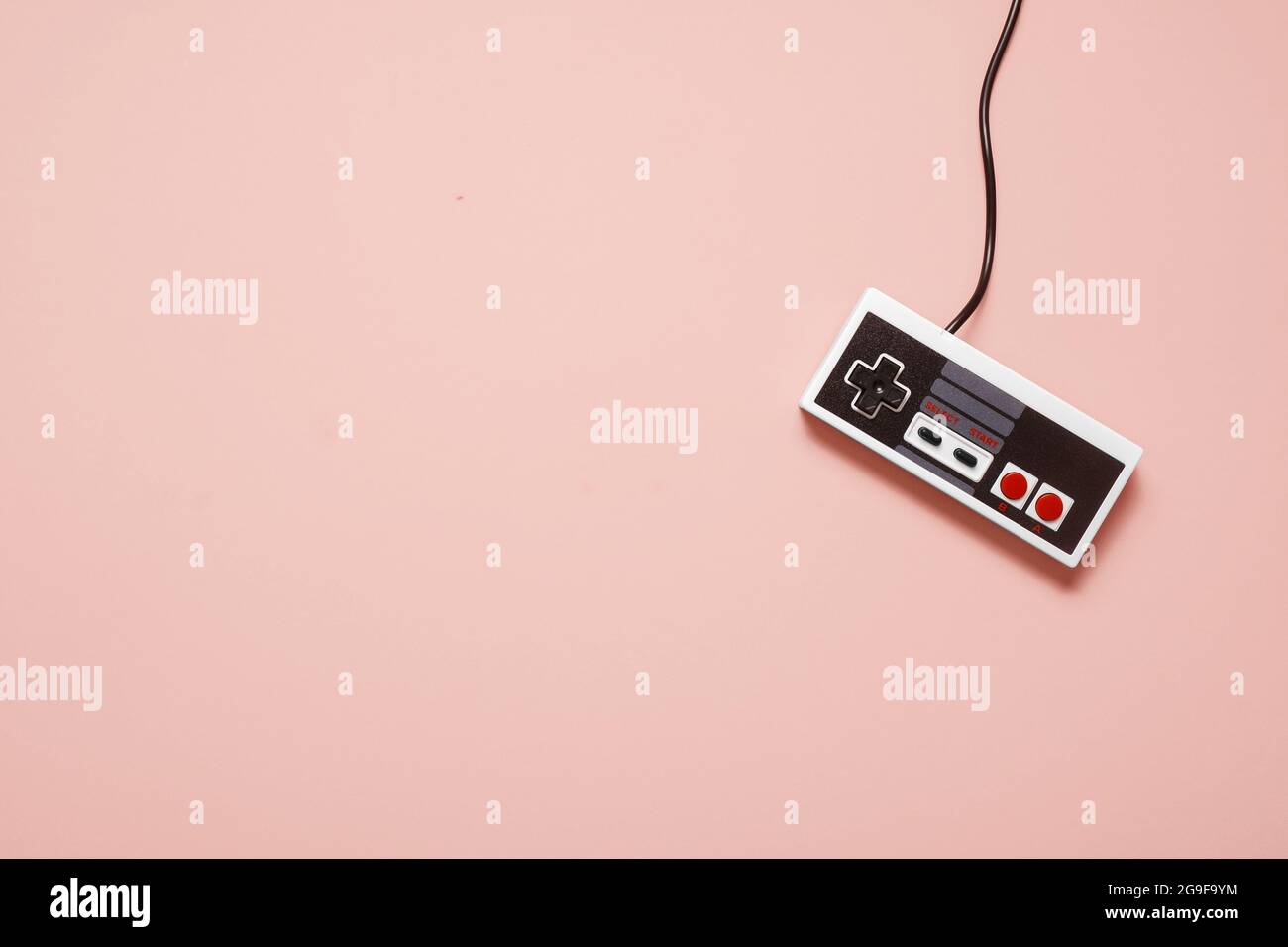 Retro vintage weißen Spielkonsolen-Controller auf einem pastellrosa Hintergrund mit Kopieplatz und Platz für Text Stockfoto