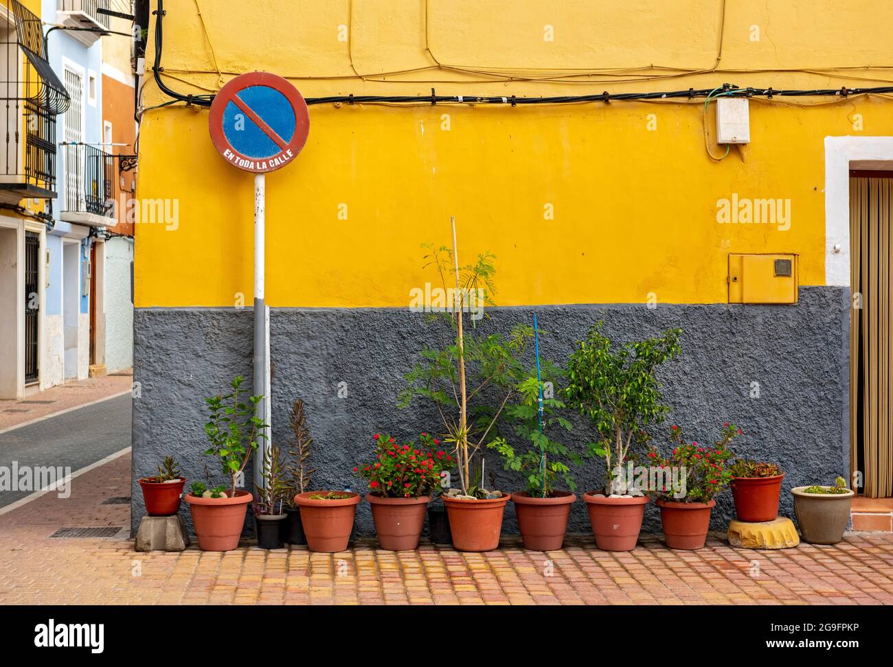 Keine wartenden Straßenschild und Blumentöpfe vor der gelben Wand, Villajoyosa, Spanien Stockfoto