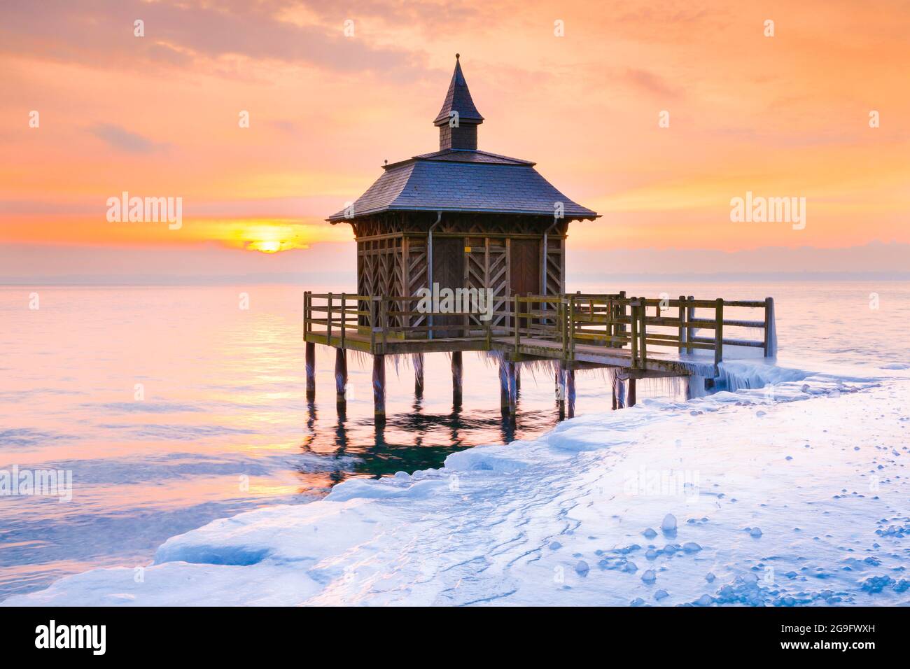 Eisige Holzbadewanne bei Sonnenaufgang am Neuchatelsee in Gorgier, Neuchatel, Schweiz Stockfoto