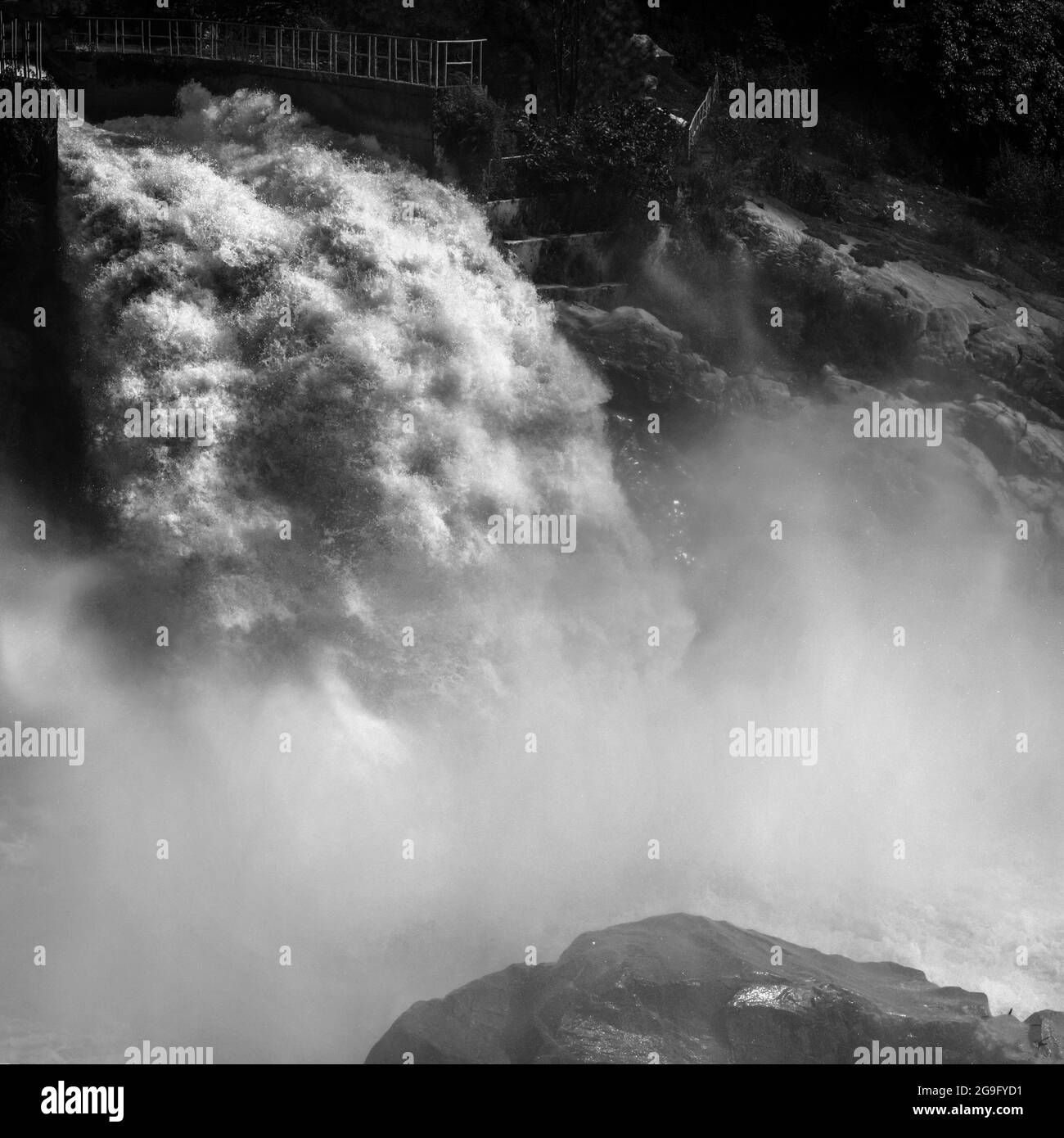Schwarz-weiß-Aufnahme einer riesigen Wassermenge, die aus einem Tunnel kommt Stockfoto