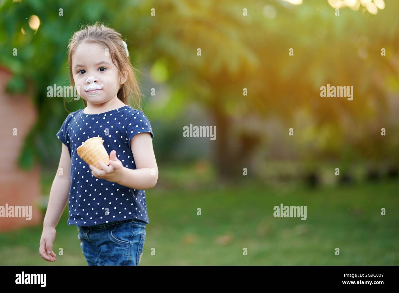 Mädchen halten Eis Kegel auf verschwommen grünen Park Hintergrund Stockfoto