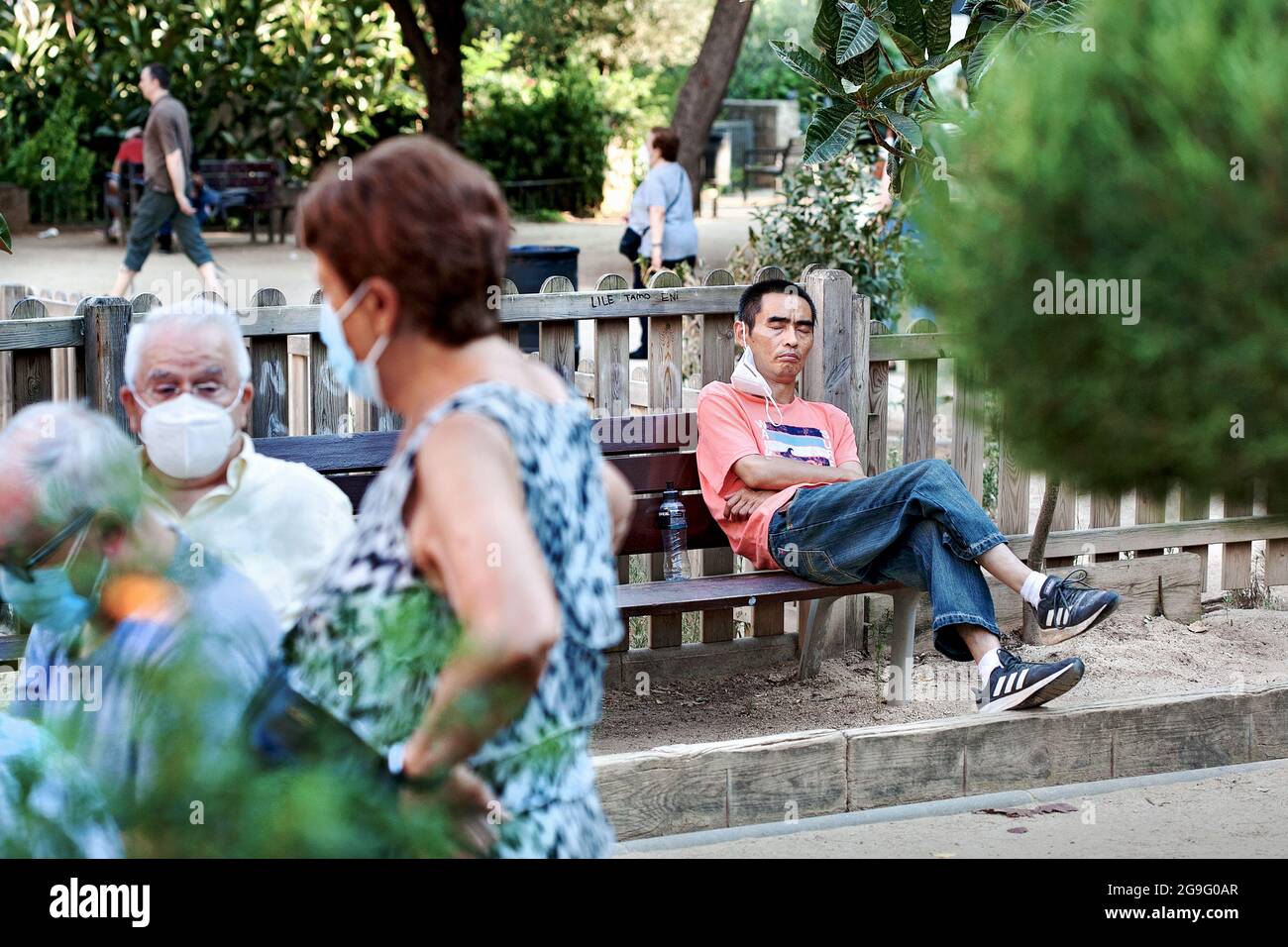 Chinesischer Mann, der im Park, Barcelona, Spanien, nippt. Stockfoto