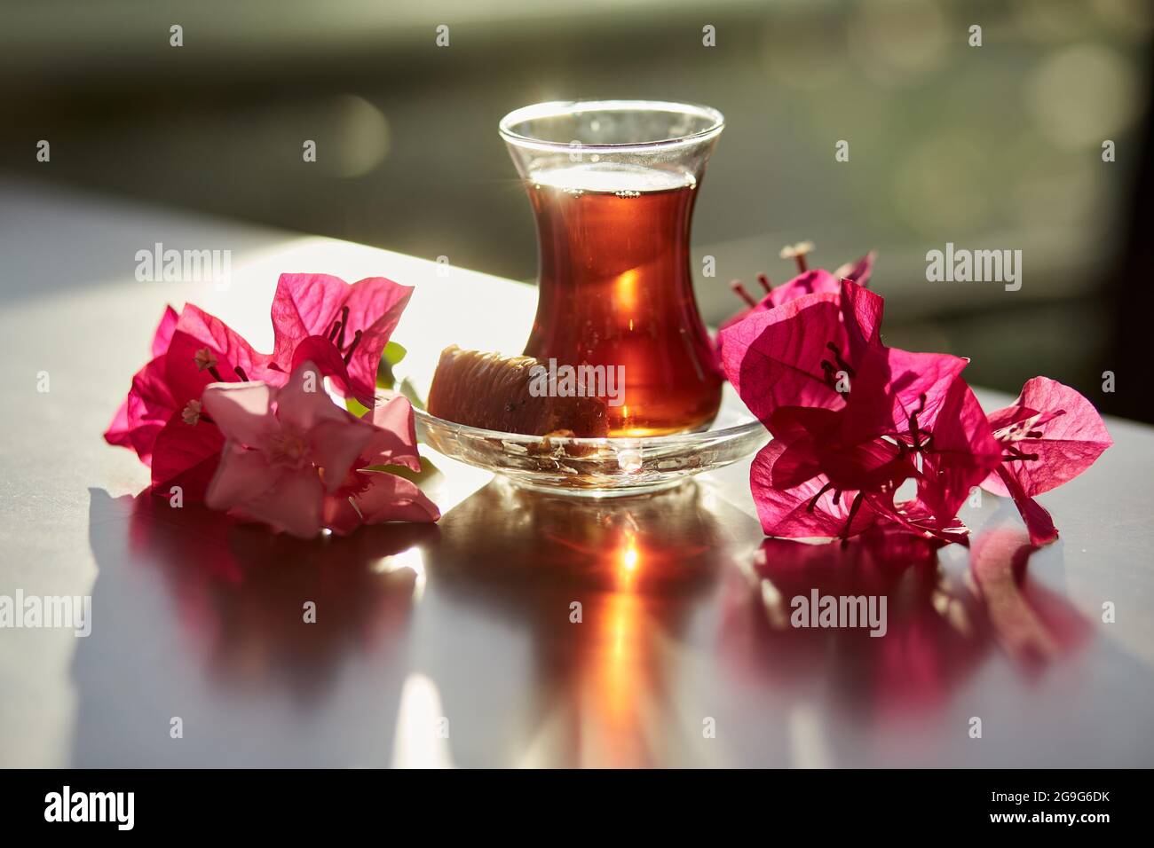 Türkisches Vergnügen und traditionelles Glas türkischen Tees mit Bougainvillea-Blumen. Romantisches Dinner-Konzept. Entspannendes, beruhigendes Getränk Reise-Türkei-Konzept. Helles, entspannendes Getränk. Hochwertige Fotos Stockfoto
