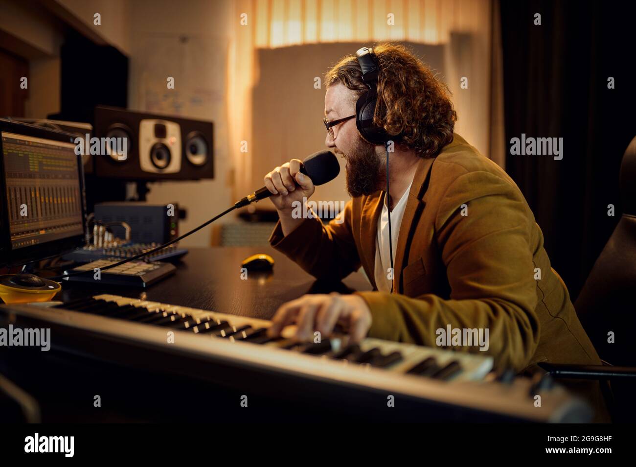 Toningenieur hält Mikrofon, Aufnahmestudio Stockfoto