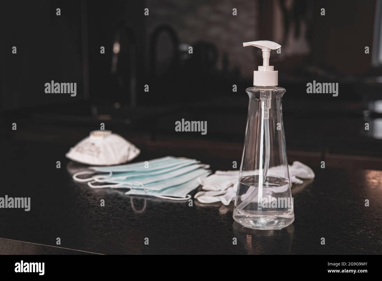 Coronavirus Coronavirus Prävention. Flasche Desinfektionshandschuhe und Masken auf dem Tisch. Reinigung der Wohnung. Stockfoto