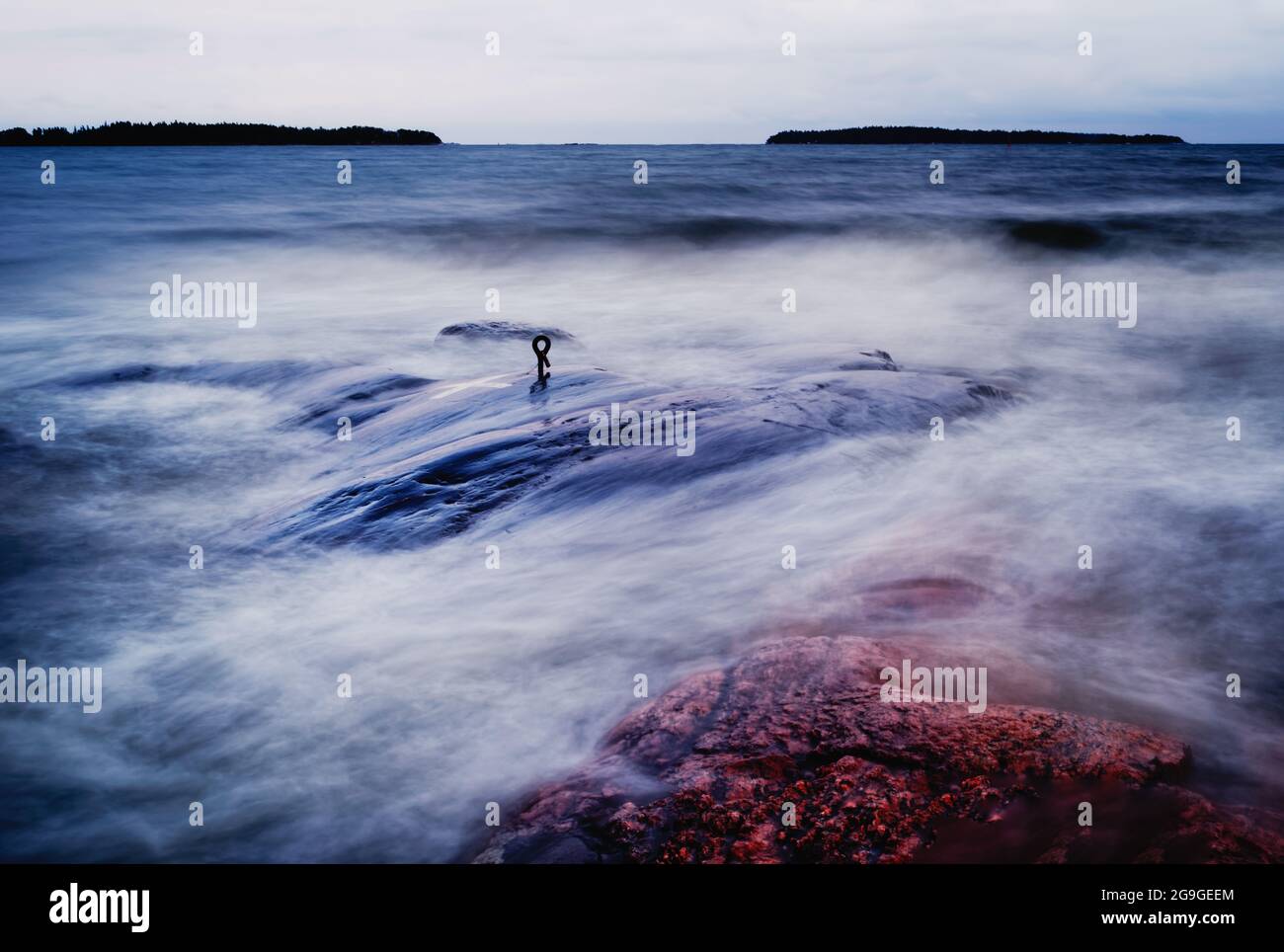 Lange Belichtung mit Wasser, das über die Felsen im Vordergrund stürzt Stockfoto