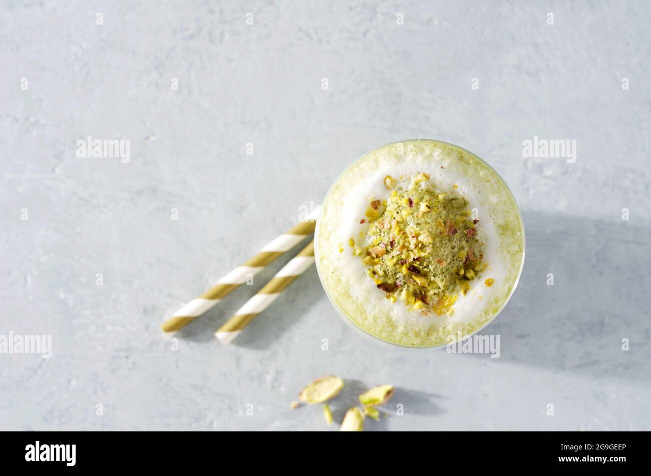 Grüner Kaffee Latte Matcha flaches Layout mit Schaum bestreut mit Nüssen auf einem Betonhintergrund und Kopierraum Stockfoto