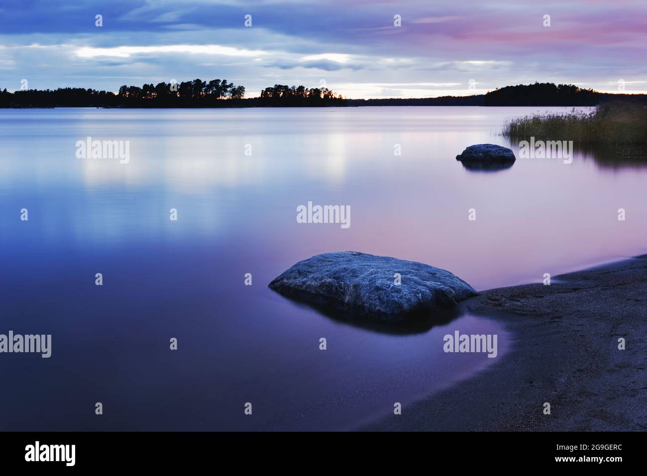Friedliche ländliche Landschaft mit langer Exposition über See mit Vordergrundufer Stockfoto