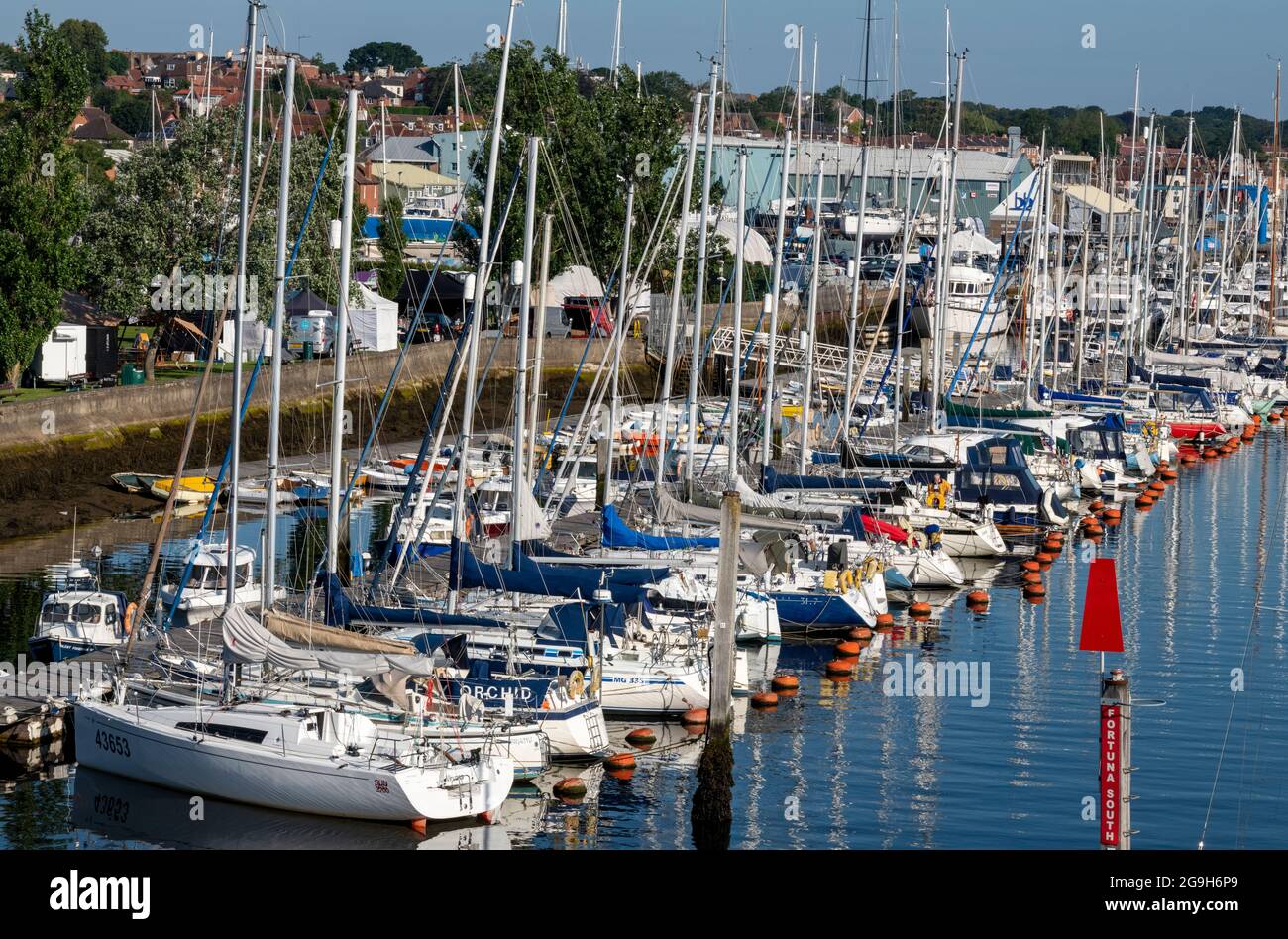 Yachten und Motorboote neben dem Yachthafen im Hafen für Kreuzfahrten von Seglern und Motorbooten in lymington, New Forest hampshire. Stockfoto
