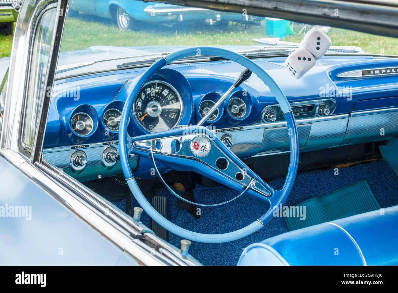 Blauer Innenraum eines klassischen Chevrolet Impala-Autos mit unscharfen Würfeln Stockfoto