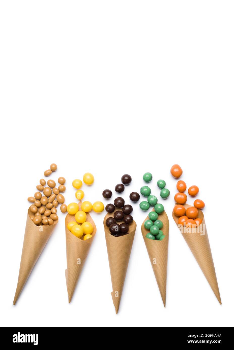 Verschiedene Geschmacksrichtungen von Schokoladenpralinen in Papiertüten auf weißem Hintergrund. Stockfoto