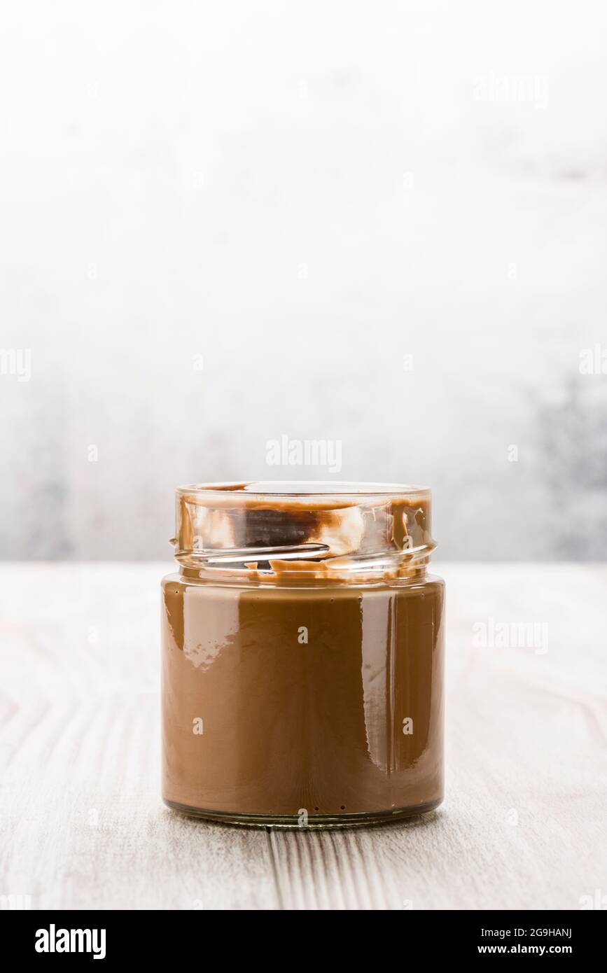 Schokoladencreme im Glas auf Holztisch Stockfoto