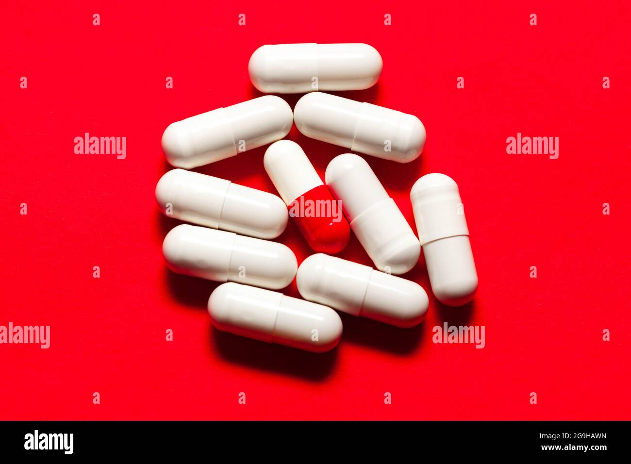 Probiotika und Antibiotika-Kapseln . Haufen Drogen auf rotem Hintergrund Stockfoto