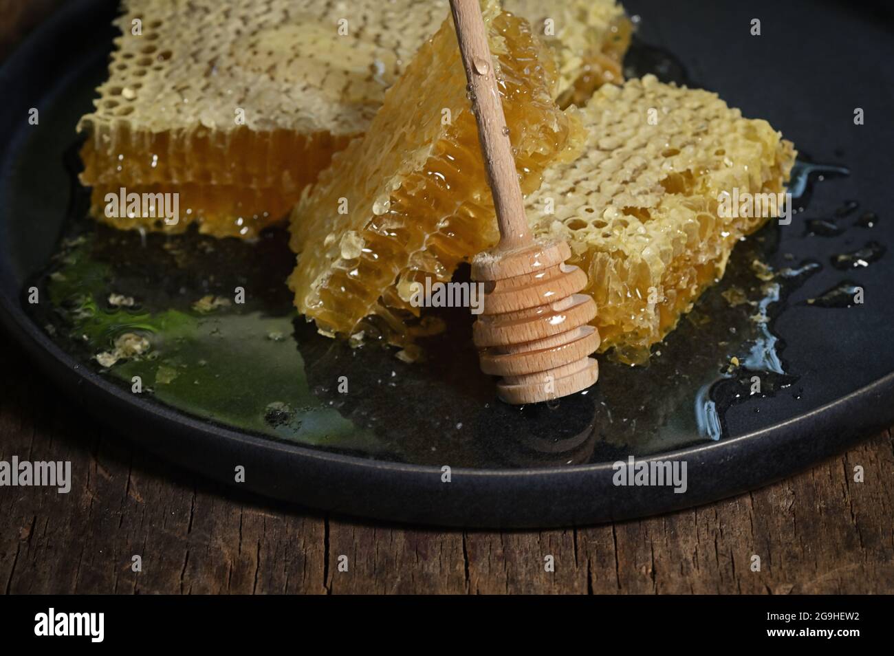 Nahaufnahme Honigwabe und Honigtaue auf Holztisch Stockfoto