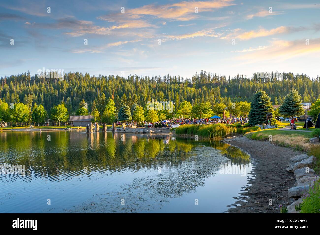 Ein kostenloses Konzert im Freien am kleinen See im öffentlichen Riverstone Park bei Sonnenuntergang in Coeur d'Alene, Idaho, USA Stockfoto