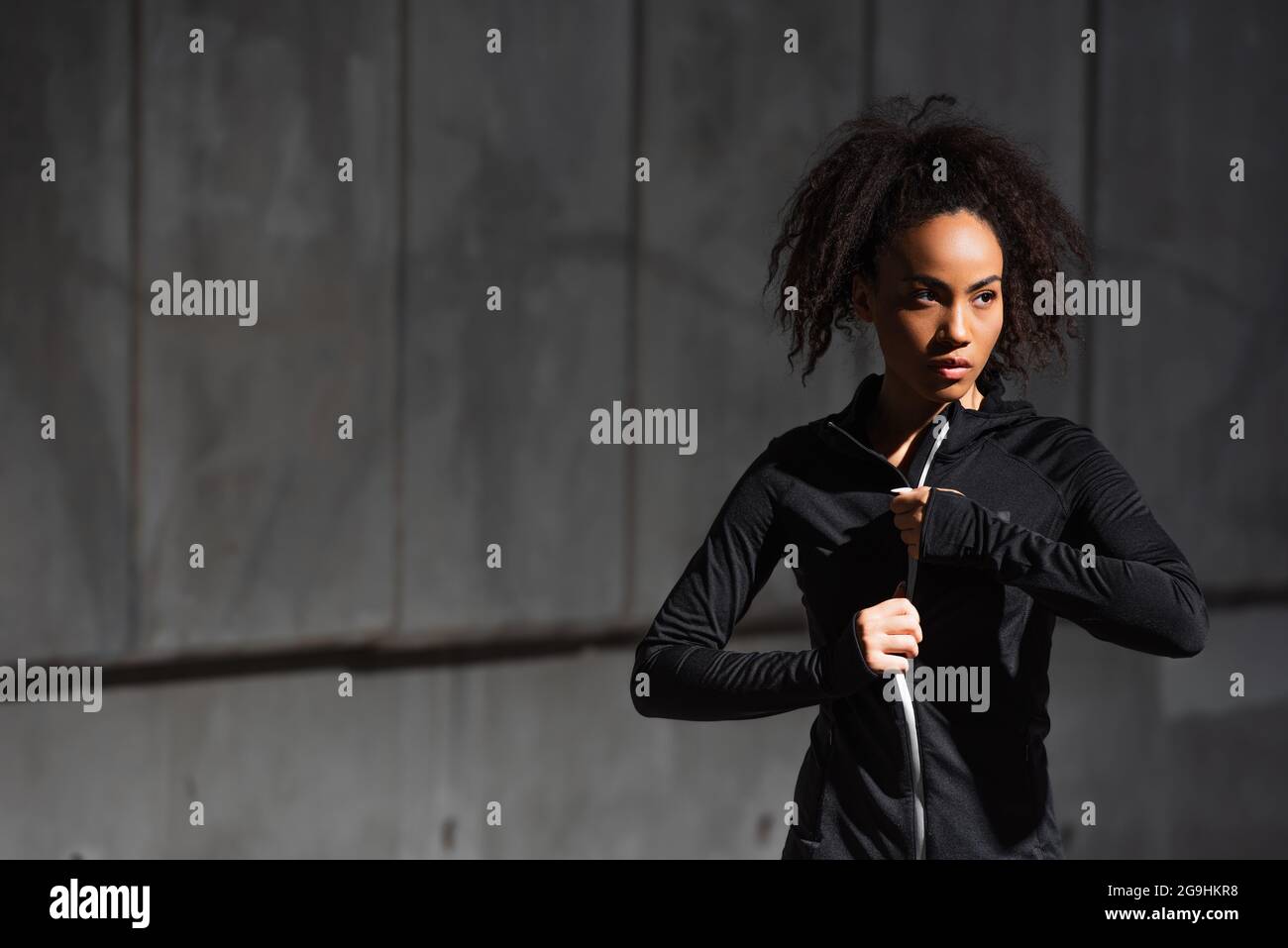 afroamerikanische Sportlerin, die im Freien eine Sportjacke trägt Stockfoto