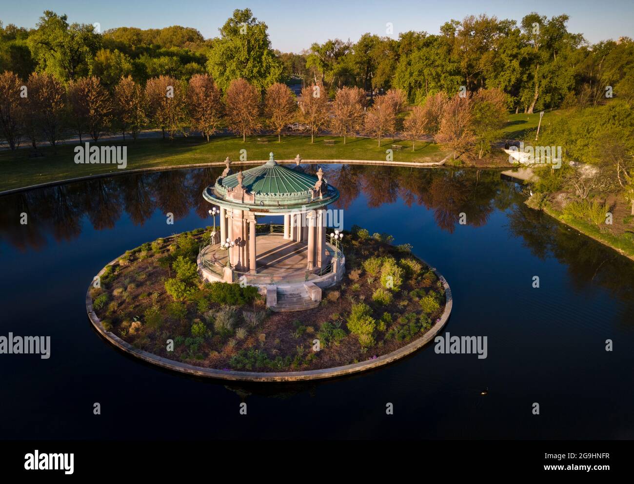 Sonnenaufgang leuchtet über dem Nathan Frank Bandstand am Pagoda Lake im Forest Park in St. Louis, Missouri, USA. Stockfoto