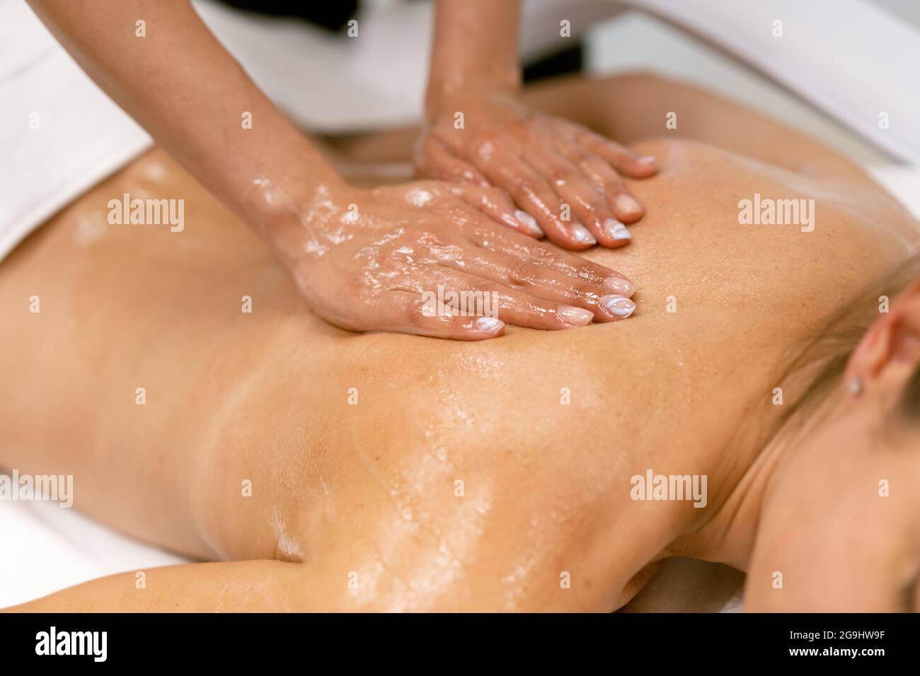 Frau erhält eine Rückenmassage mit Massagekerzenöl. Stockfoto