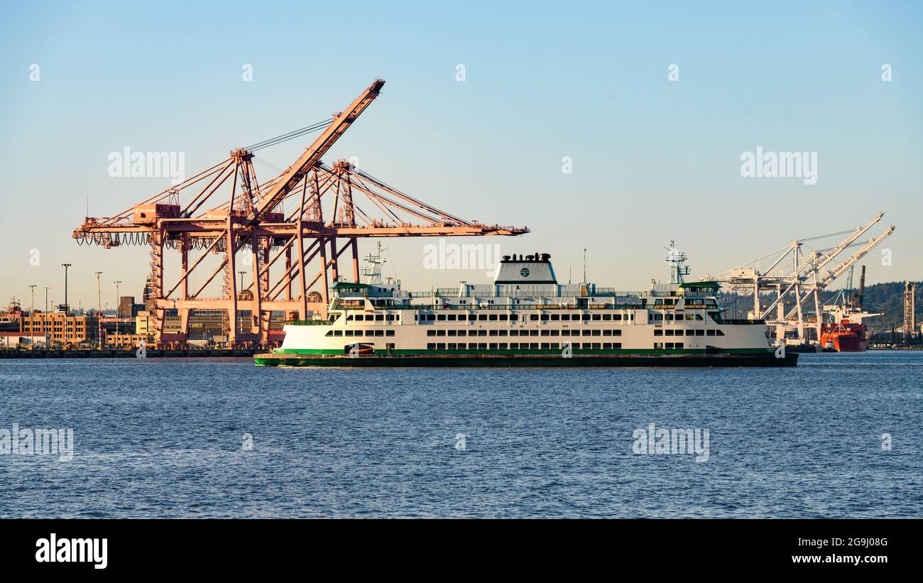 Seattle - 25. Juli 2021; Washington State Ferry Chimacum, das Frachtkrane passiert, wenn es sich dem Hafengebiet von Seattle nähert Stockfoto